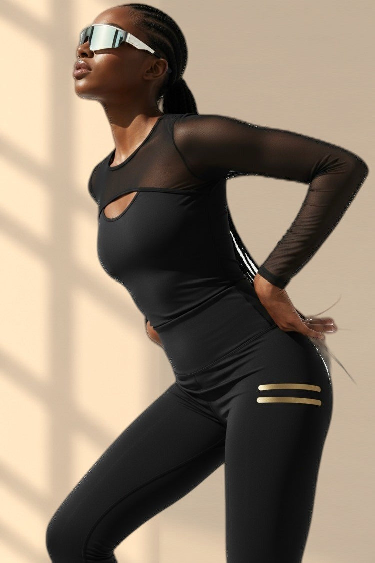 Penché en arrière dans le haut. Le legging noir a deux courtes rayures dorées sur la cuisse.