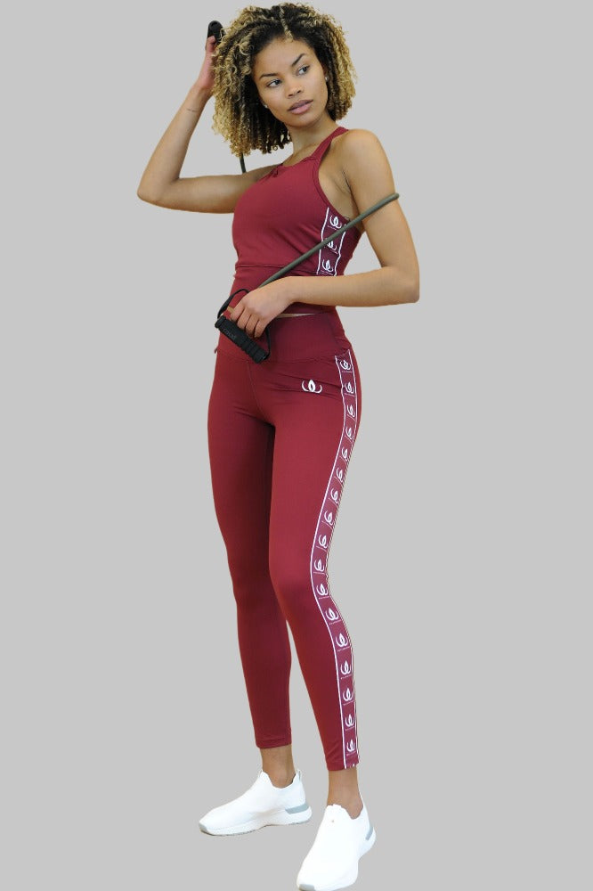 Mit einem Springseil in der Hand werden die weinroten Leggings zu einem Croptop in derselben Farbe getragen.