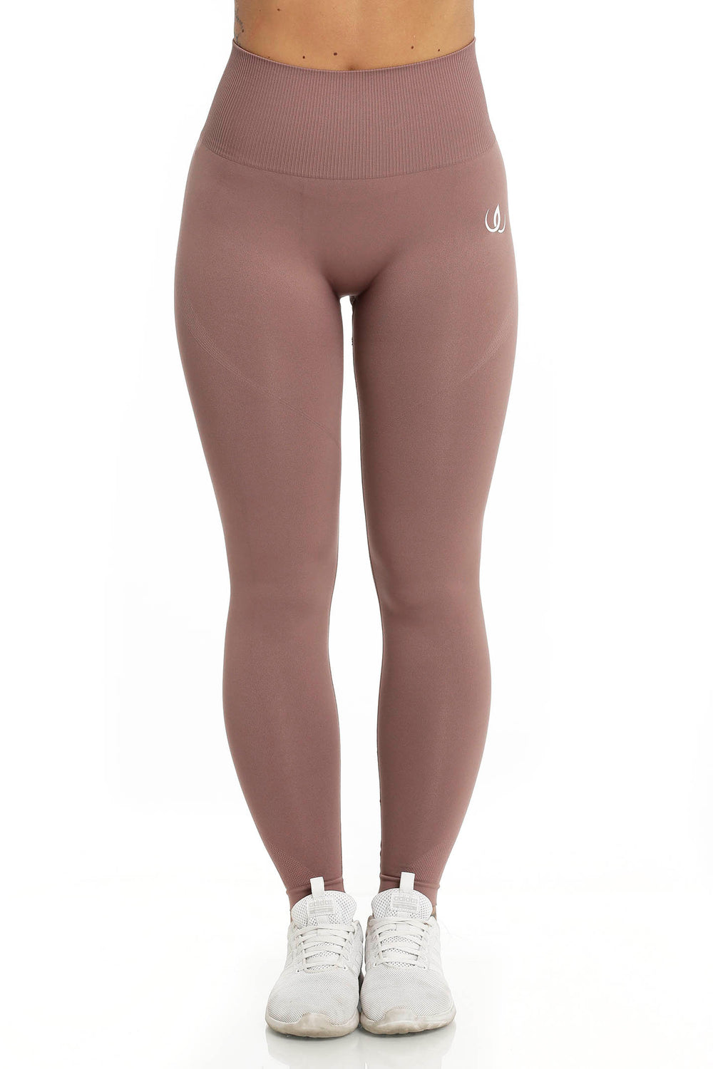 Ein weißes Logo sitzt an der Hüfte der rosébraunen Leggings, der Bund gerippt und hoch.
