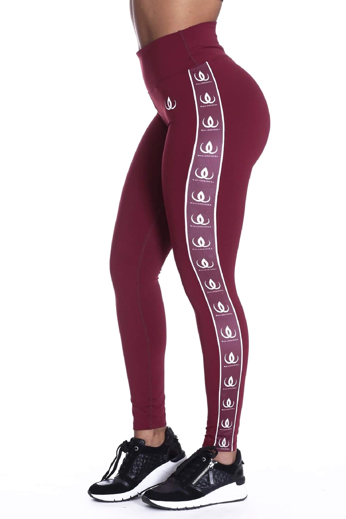Die hohe Taille der weinroten Leggings, mit weißem Logoband an der Seite und schwarzen Schuhen unten.