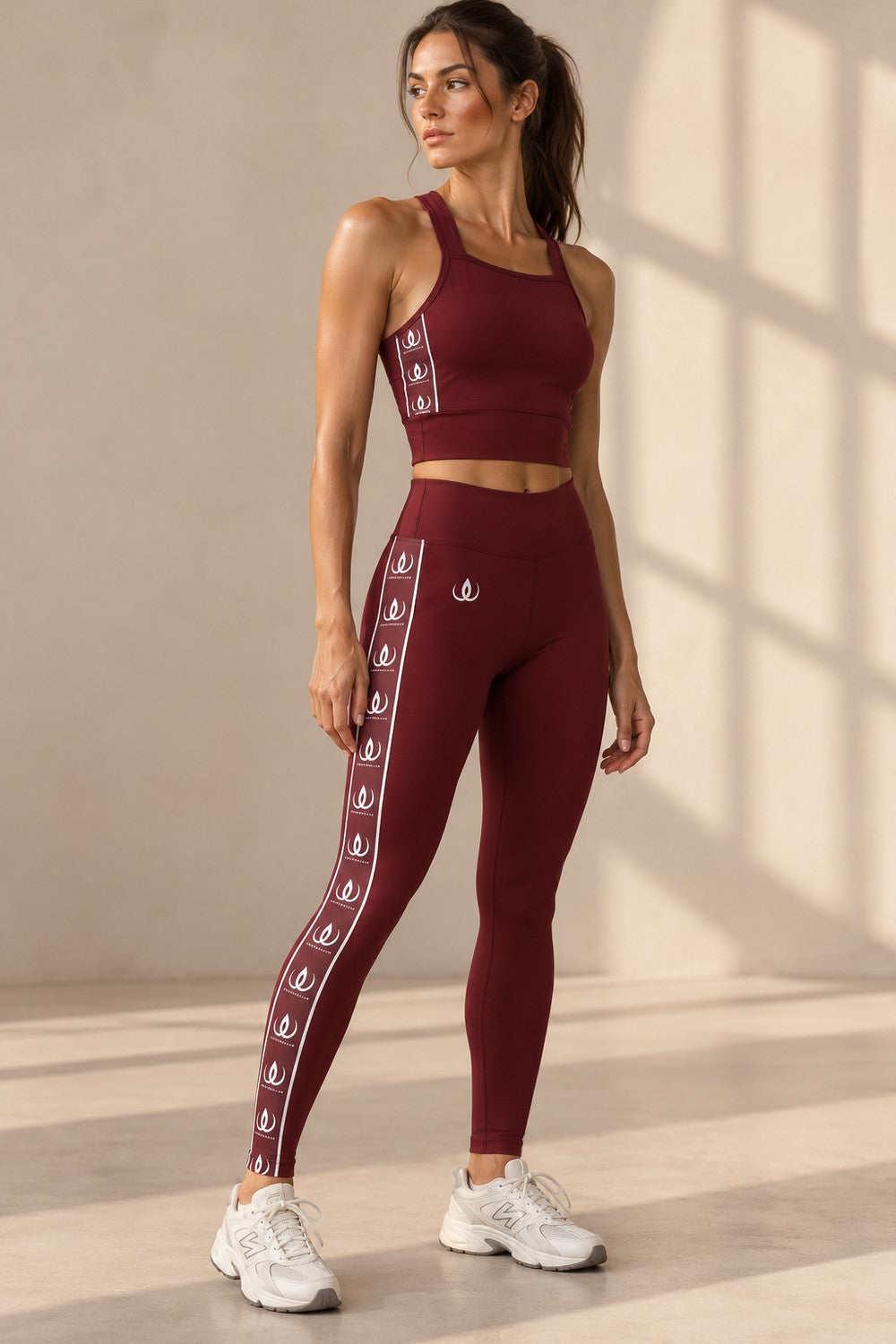 Lux Maroon Träningstights i helfigur med vitt loggband längs hela benet, till vita sneakers.