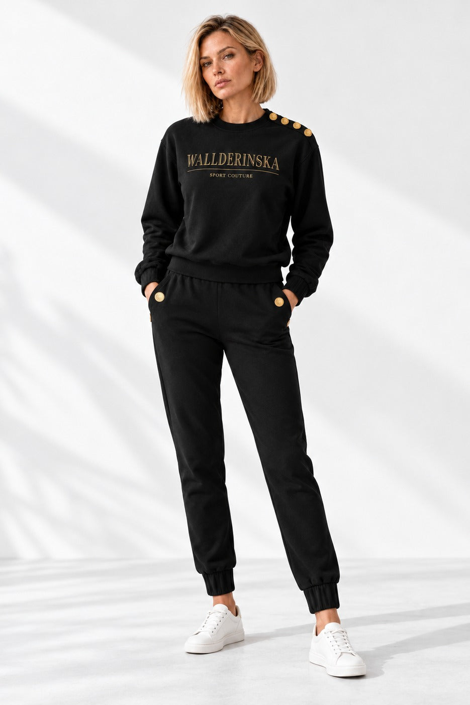 Edge Gold Button Sweater e Pants neri, figura intera in studio con sneakers bianche.