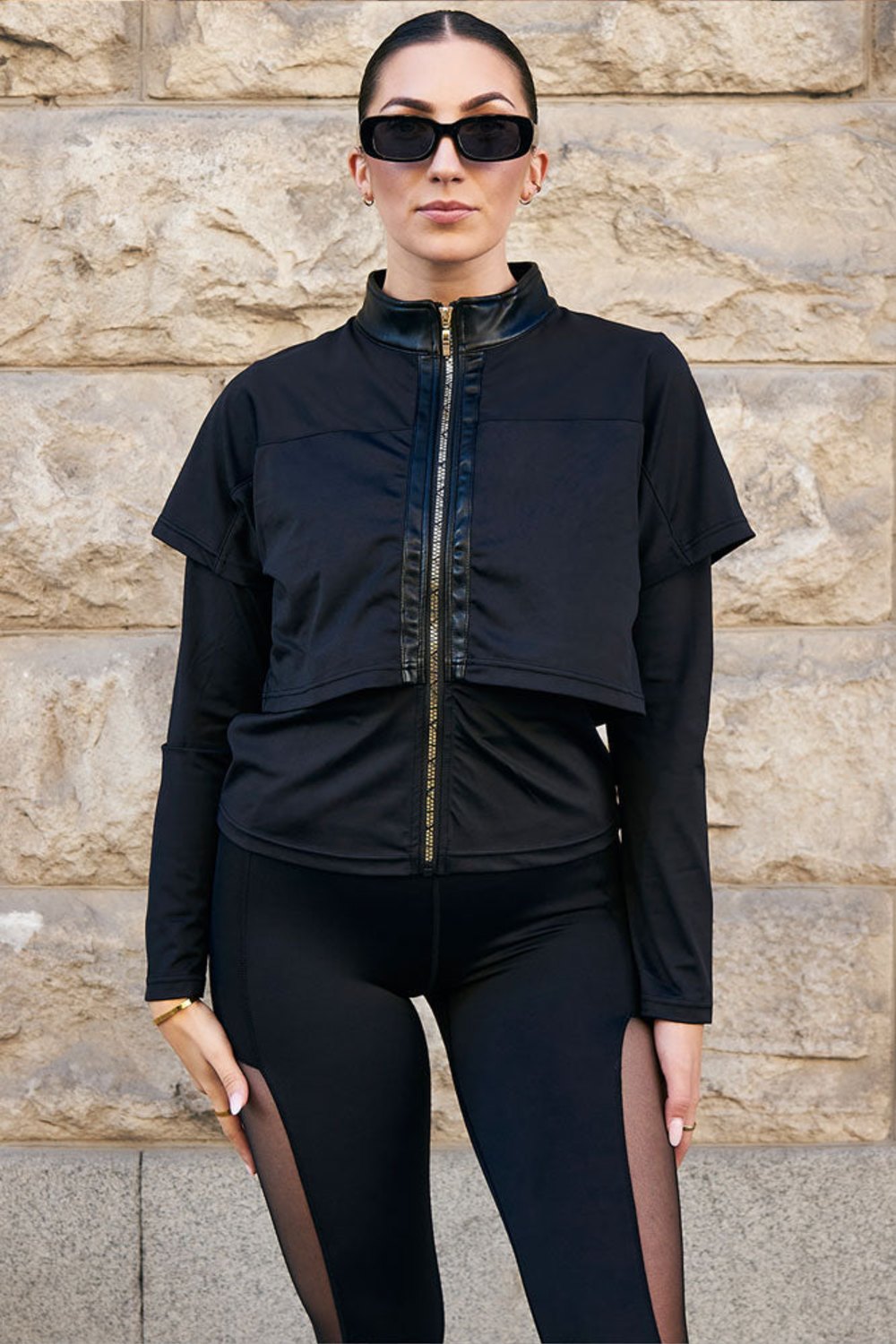 Edge Trainingsjacke Gold Zip mit goldfarbenem Reißverschluss mittig vorn, getragen zu schwarzen Leggings mit Mesh.