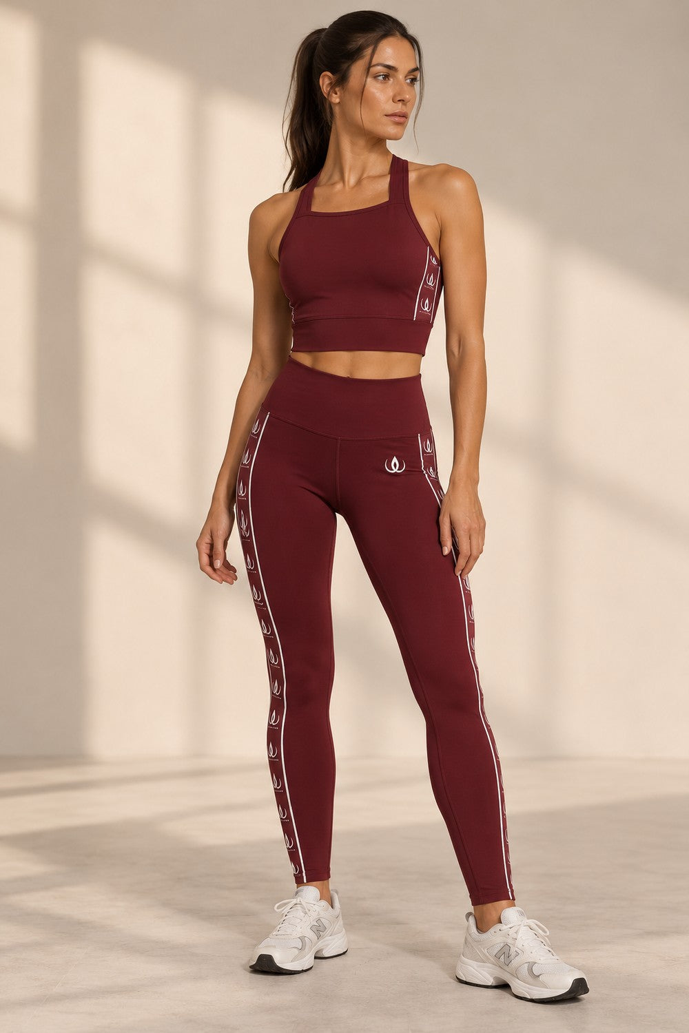 Vinröda tights med hög midja och vitt loggband längs sidan, burna till matchande croptop.